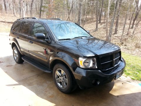 2007 Dodge Durango - A black 2007 Dodge Durango SUV is parked on a concrete driveway with trees in the background.