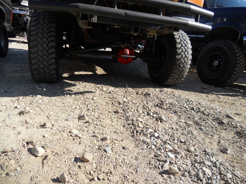 Rear underside of a lifted 1987 Ford Bronco with large tires and a red differential