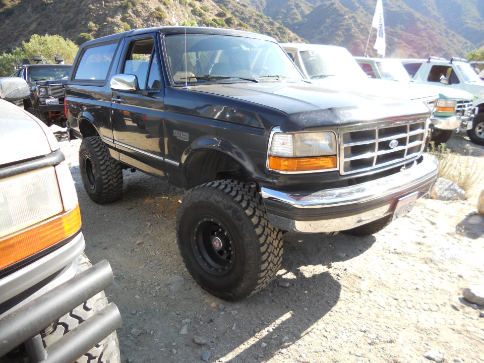 Dark blue 1992 Ford Bronco with lifted suspension and off-road tires parked outdoors