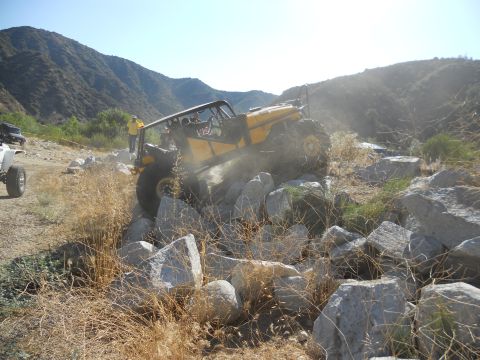1986 Ford Bronco - An off-road buggy tackles a challenging rocky obstacle course, with a second vehicle in the distance.