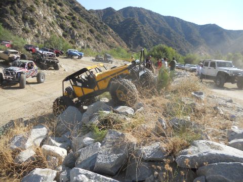 1986 Ford Bronco - Off-road vehicles tackle a challenging rocky trail in a mountainous area.