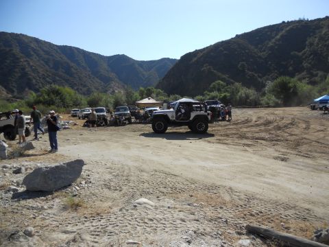 1986 Ford Bronco - A group of off-road vehicles are gathered in a scenic canyon area on a sunny day.