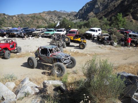 1986 Ford Bronco - A collection of off-road vehicles gathered in a scenic, mountainous terrain.