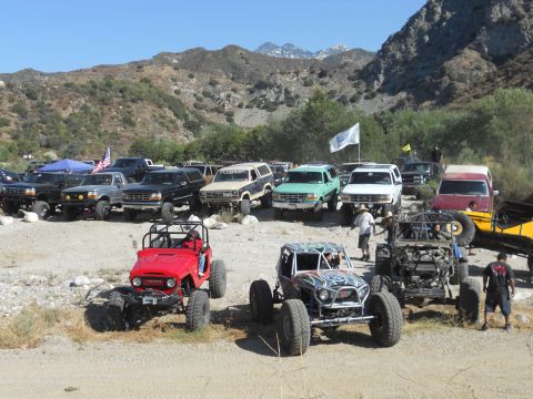 1986 Ford Bronco - A group of off-road vehicles are gathered in a scenic, mountainous area.