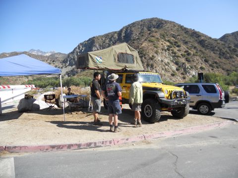 1986 Ford Bronco - Two vehicles, a modified Jeep and a Honda CR-V, are parked on a dirt lot with mountains in the background.