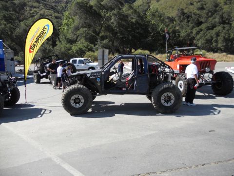 1986 Ford Bronco - Modified off-road buggy with roll cage and large tires at an outdoor event.