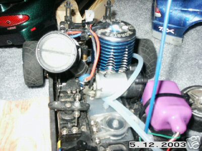 1998 Mercury Sable - This image shows the engine and fuel tank of a radio-controlled car, with parts of other RC vehicles visible in the background.