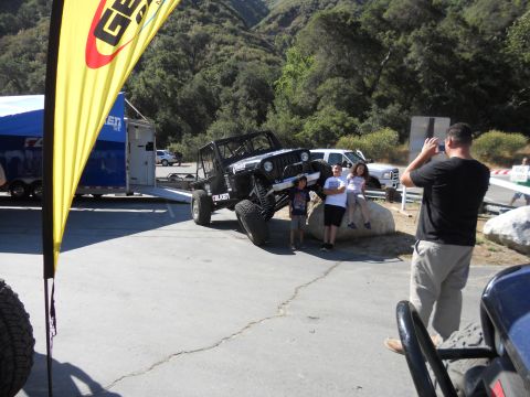 1986 Ford Bronco - A modified off-road vehicle is the center of attention at an outdoor event.