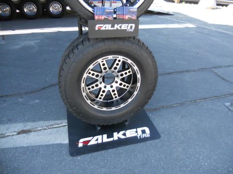 1986 Ford Bronco - Falken tire and wheel display at an event, with multiple tires stacked.
