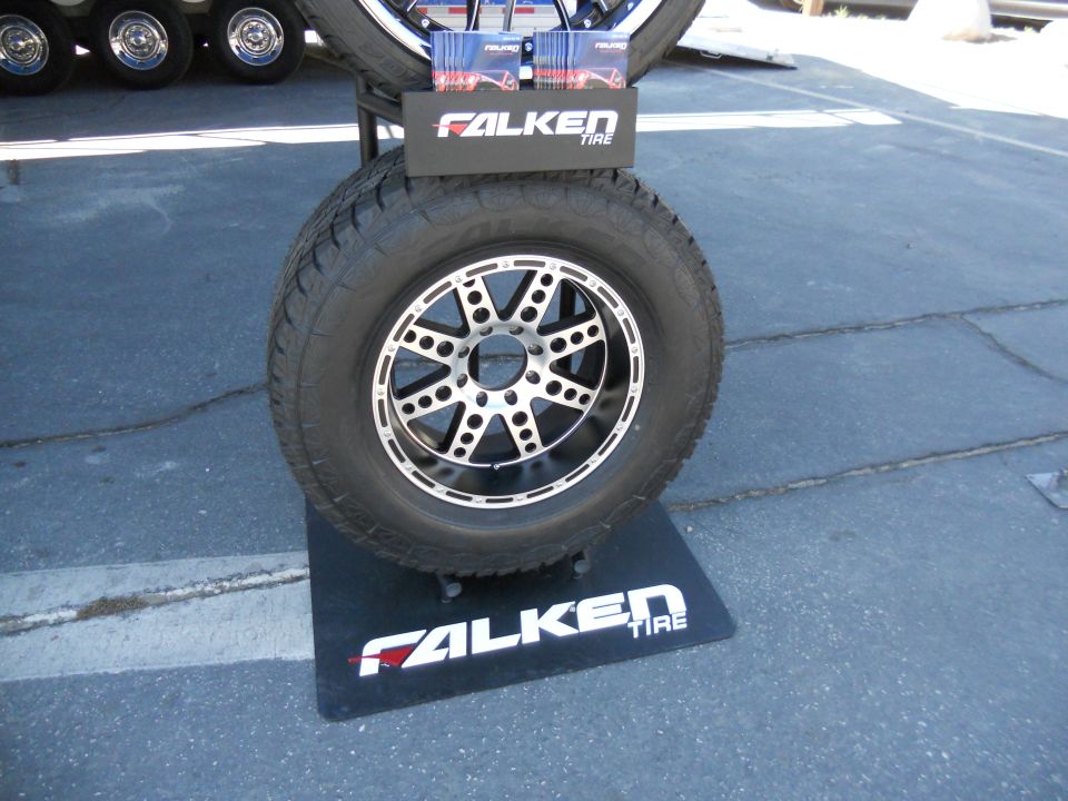 Falken tire on a display stand with brochures, part of a larger tire display in background