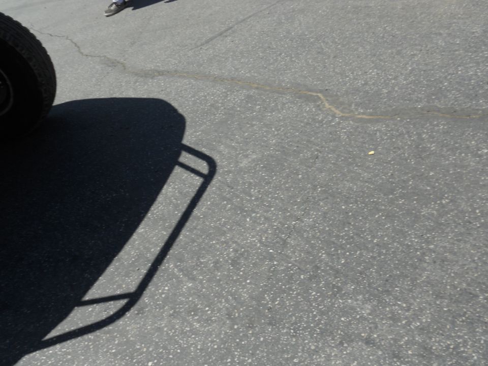 Tire and shadow of a vehicle on asphalt
