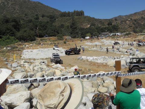 1986 Ford Bronco - Jeeps tackle a challenging off-road course with spectators observing the action.