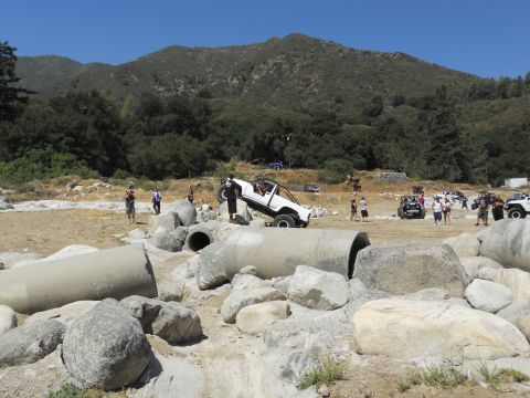 1986 Ford Bronco - An off-road event with multiple vehicles and spectators gathered in a rocky, outdoor terrain.