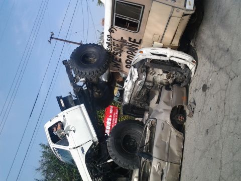 1986 Ford Bronco - Multiple vehicles involved in a severe accident, with one car completely crushed.