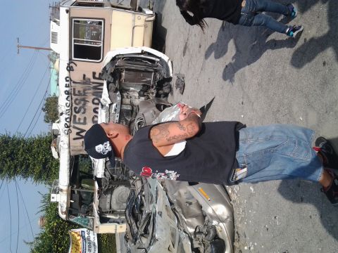 1986 Ford Bronco - A man stands near a severely damaged RV and car, both appear to be involved in a crash.
