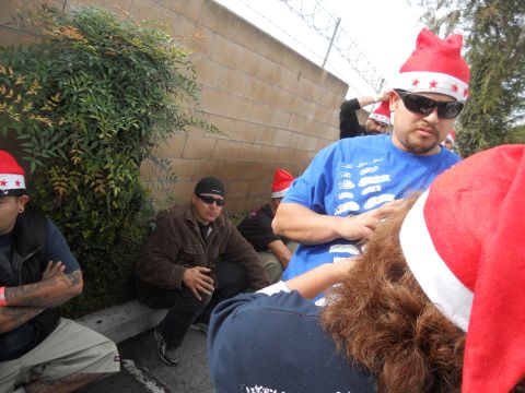 1986 Ford Bronco - Several people in Santa hats are gathered outdoors near a wall and some greenery.