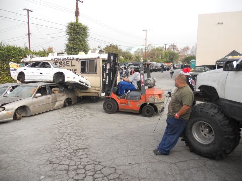 1986 Ford Bronco - A forklift is used to stack cars as part of a toy drive car crush event.