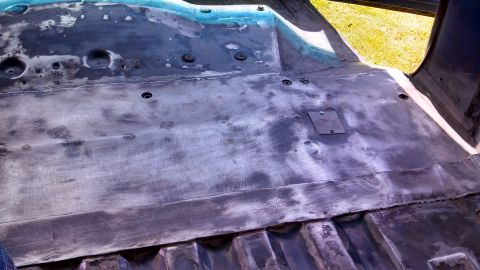 1979 Ford Bronco - The floor pan of a vehicle is shown stripped down to bare metal, revealing its construction.