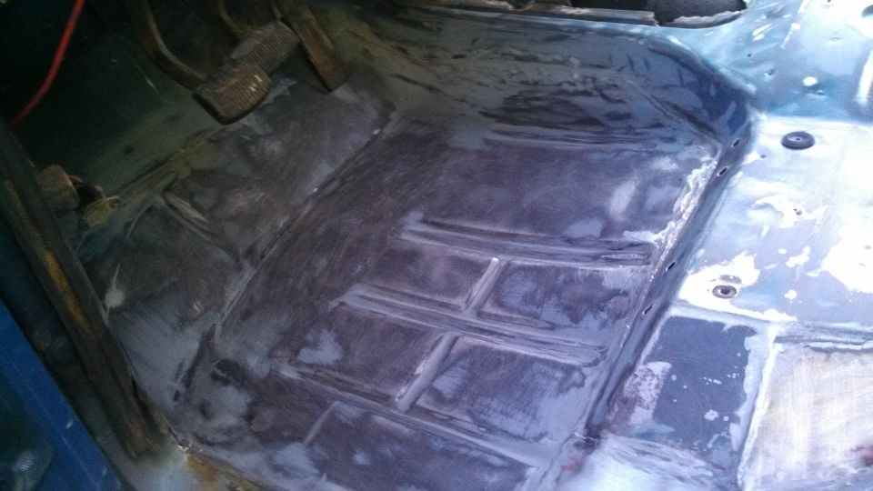 vehicle floor with pedals visible, appears to be undergoing repair or restoration