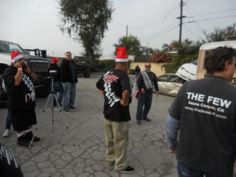 1986 Ford Bronco - A group of people in Santa hats are gathered around damaged vehicles in a parking lot.