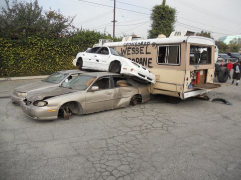 1986 Ford Bronco - Multiple wrecked vehicles are stacked and damaged in a scene that appears to be part of a car crush event.