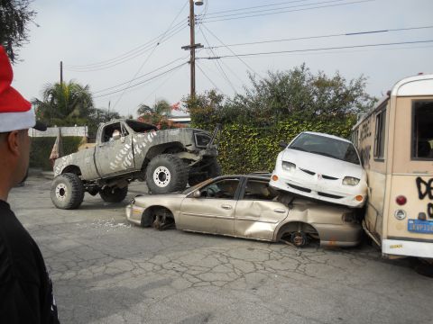 1986 Ford Bronco - A lifted truck has crushed several cars, creating a chaotic scene with a bus nearby.