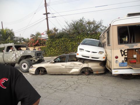 1986 Ford Bronco - A chaotic scene shows multiple vehicles involved in a collision, with cars stacked and damaged.