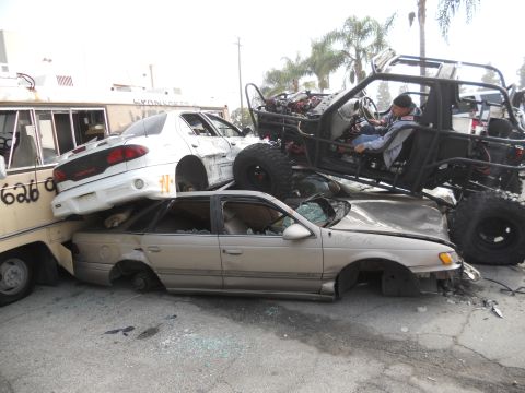 1986 Ford Bronco - A chaotic scene shows multiple damaged vehicles, including a custom off-road buggy, piled together.