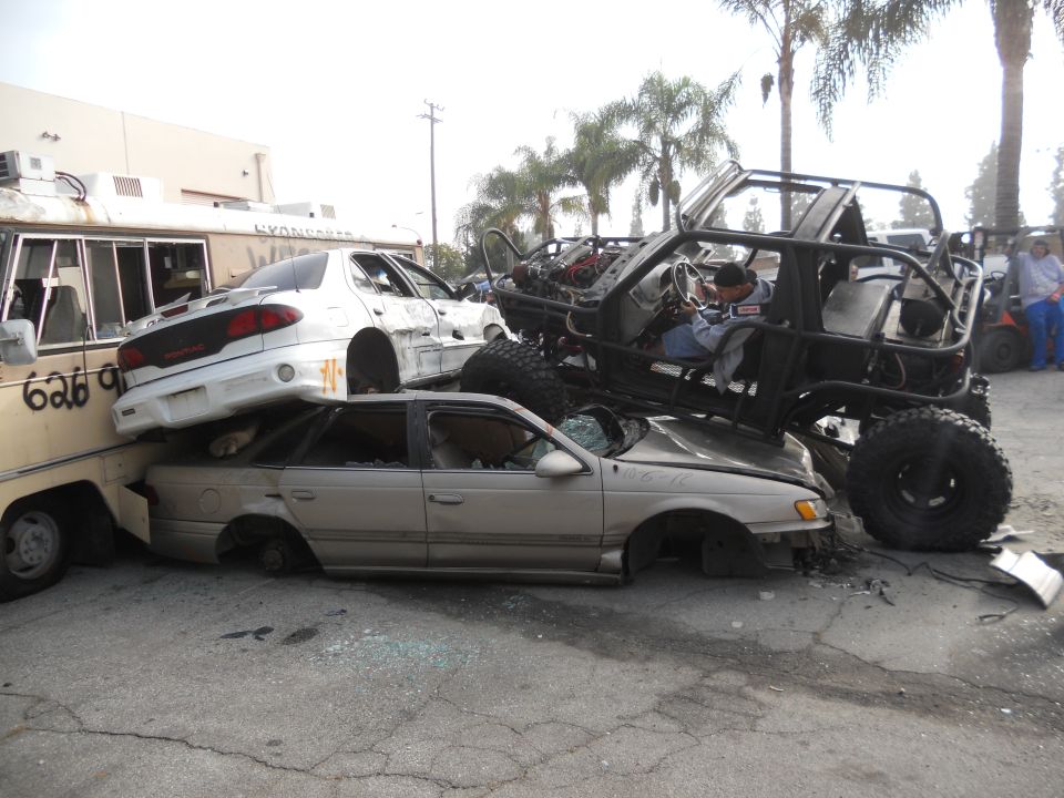 Modified off-road vehicle atop wrecked cars