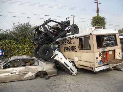 1986 Ford Bronco - A chaotic scene with a bus, a buggy, and multiple crushed cars.