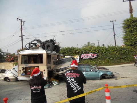 1986 Ford Bronco - A chaotic scene with multiple wrecked vehicles, including a bus and sedans, under a cloudy sky.