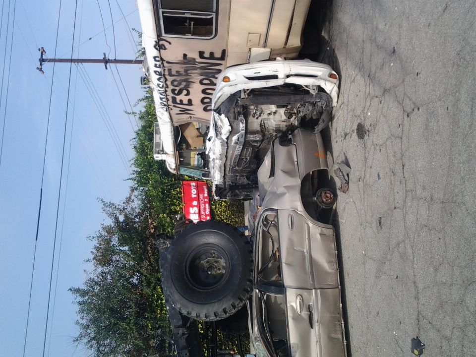 car smashed into side of bus, front end destroyed, wheel missing
