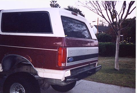 1992 Ford Bronco - Rear view of a maroon and white 1992 Ford Bronco, showing its distinctive body style and rear panel.