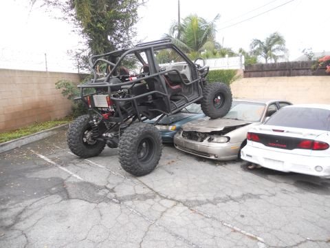 1986 Ford Bronco - Custom off-road buggy is parked on top of three wrecked cars.