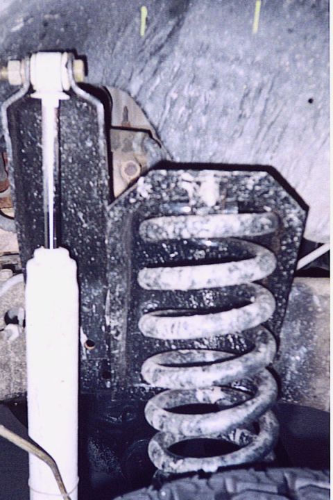 1992 Ford Bronco - This image shows the suspension system of a vehicle, focusing on the coil spring and shock absorber.