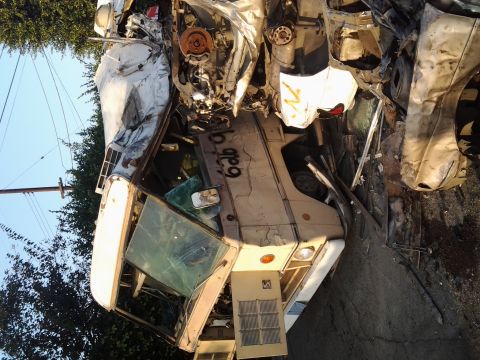 1986 Ford Bronco - This heavily damaged van, with the number '626' visible on its side, is part of a pile of crushed vehicles.