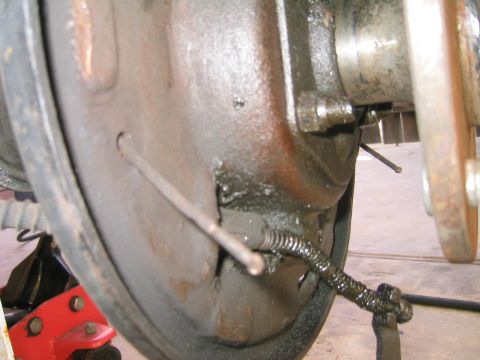 1969 Ford Bronco - Close-up view of a rear drum brake assembly, showing the brake cable and spring mechanism.