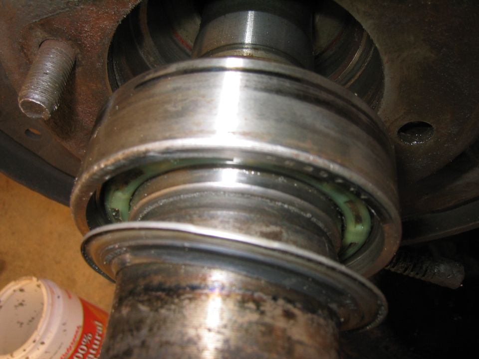 Close-up of a wheel bearing assembly with green grease visible