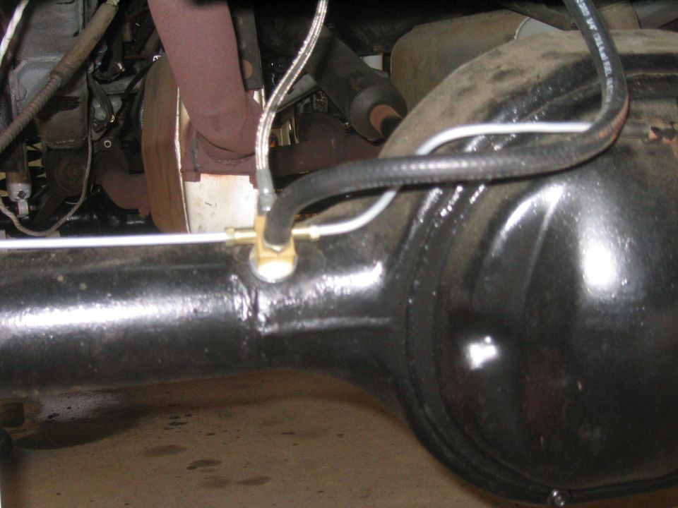 Rear axle assembly with brake line and exhaust manifold