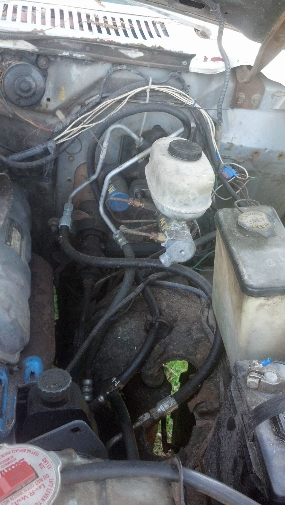 Engine bay with brake master cylinder, washer fluid tank, and wiring