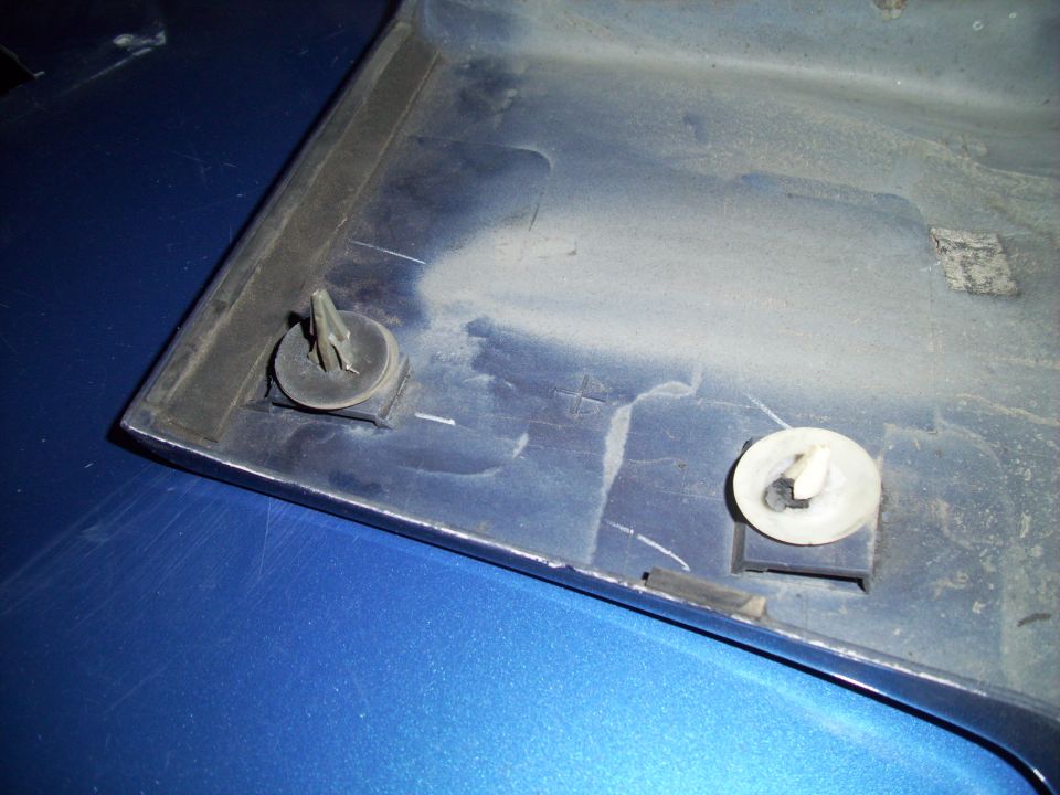 Close-up of a blue plastic trim piece with two mounting clips attached