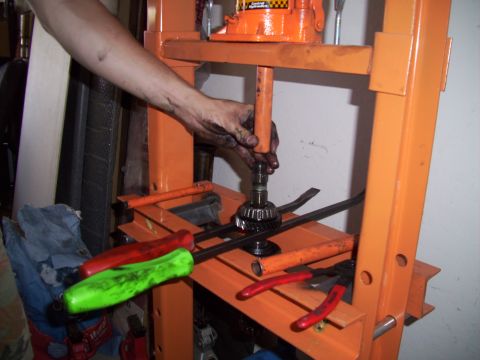 1995 Ford Probe - A gear is being pressed using a hydraulic press, with several tools visible in the foreground.
