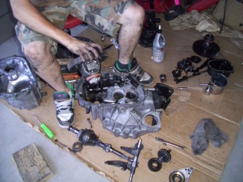 1995 Ford Probe - Car transmission and related parts laid out on the floor for repair.