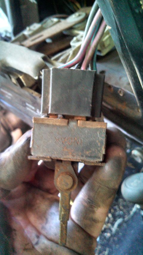 1979 Ford Bronco - Close-up of a corroded electrical connector and wiring harness, with a small metal lever attached.