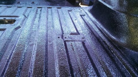 1979 Ford Bronco - The bed of a truck has been coated with a dark, textured spray-on liner.