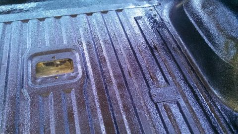 1979 Ford Bronco - The textured surface of a truck bed liner is visible, showing ribbed patterns and a central cutout.