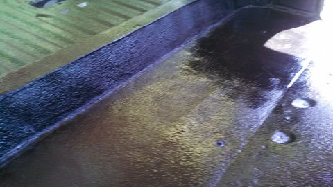 1979 Ford Bronco - The interior floor of a vehicle shows a dark, textured coating, possibly for protection or sound dampening.