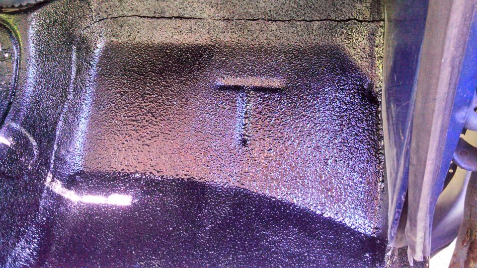 Underside of vehicle with T-shaped indentation and textured coating