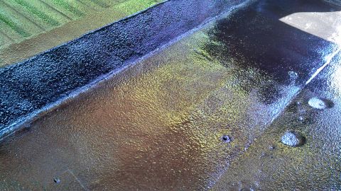 1979 Ford Bronco - The textured surface of the vehicle's undercoating shows a metallic sheen with hints of blue and yellow.