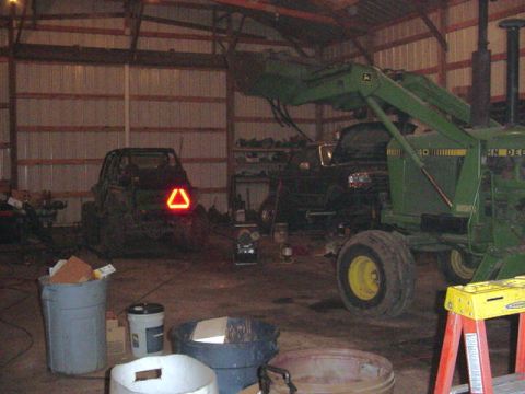 1992 Ford Bronco - A John Deere tractor and an ATV are parked inside a barn.